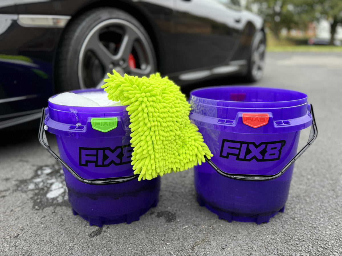 Detailer working around vehicle with bucket system